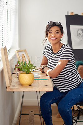 Buy stock photo Portrait of an attractive and artistic young woman using a laptop while working inside her studio at home