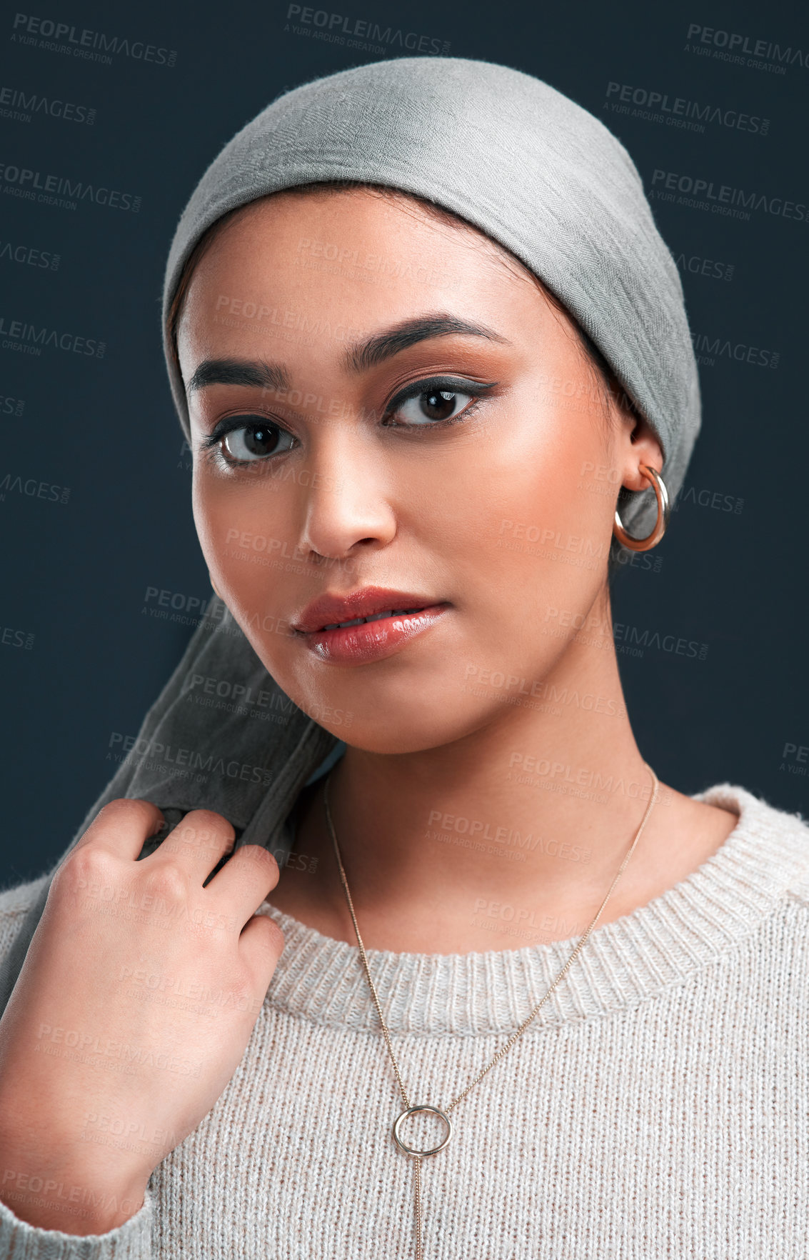Buy stock photo Cropped shot of an attractive young woman wearing a headscarf and standing alone against a black background in the studio
