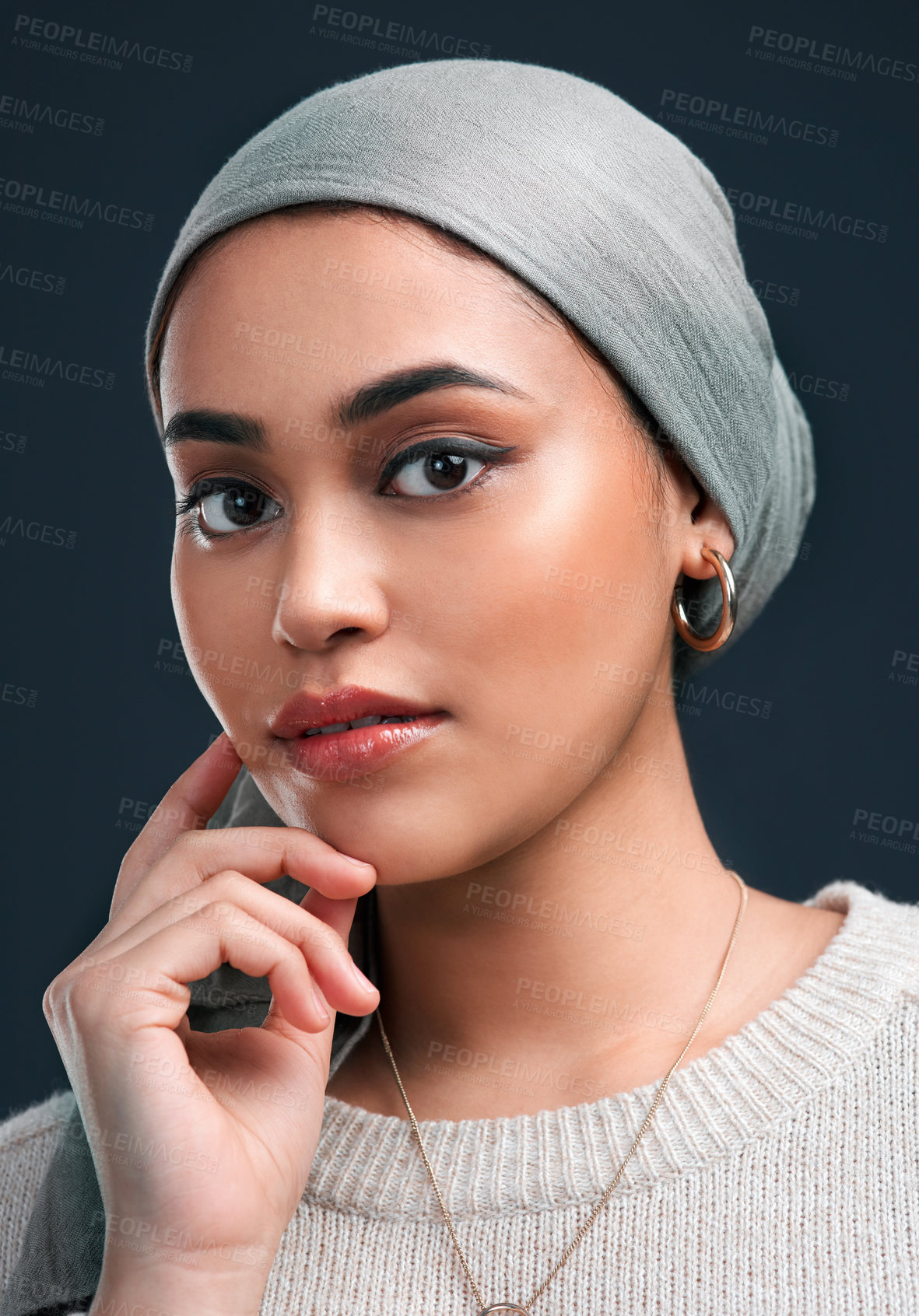 Buy stock photo Cropped shot of an attractive young woman wearing a headscarf and standing alone against a black background in the studio