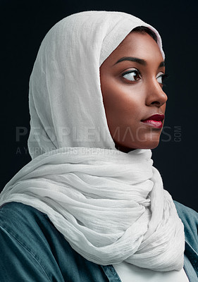 Buy stock photo Cropped shot of an attractive young woman wearing a hijab and standing alone against a black background in the studio