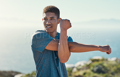 Buy stock photo Cropped shot of a handsome young man stretching before his run
