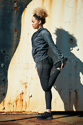 Buy stock photo Shot of a young woman warming up before her workout outdoors