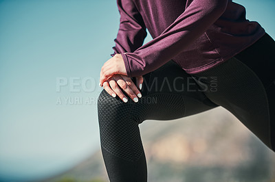 Buy stock photo Cropped shot of a young woman stretching outdoors before her run