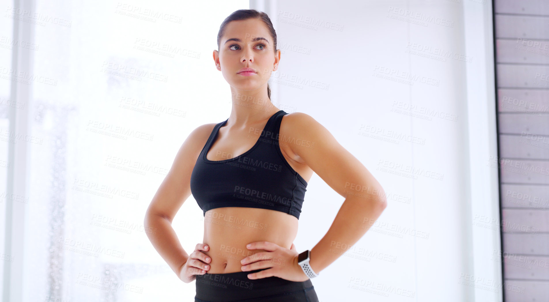 Buy stock photo Shot of an attractive young sportswoman posing with her hands on her hips at the gym