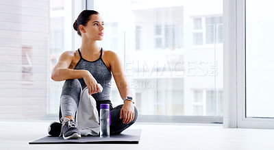 Buy stock photo Full length shot of an attractive young woman sitting down and taking a break at the gym