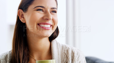 Buy stock photo Shot of an attractive young woman smiling and feeling cheerful while relaxing at home