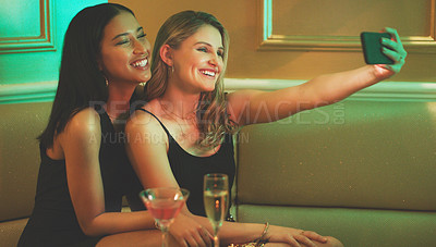 Buy stock photo Shot of two young women taking a selfie together in a nightclub