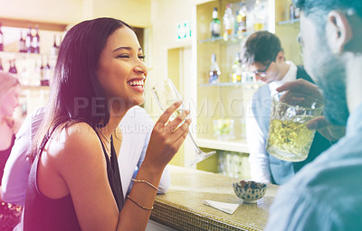 Buy stock photo Shot of a young man and woman having drinks in a nightclub