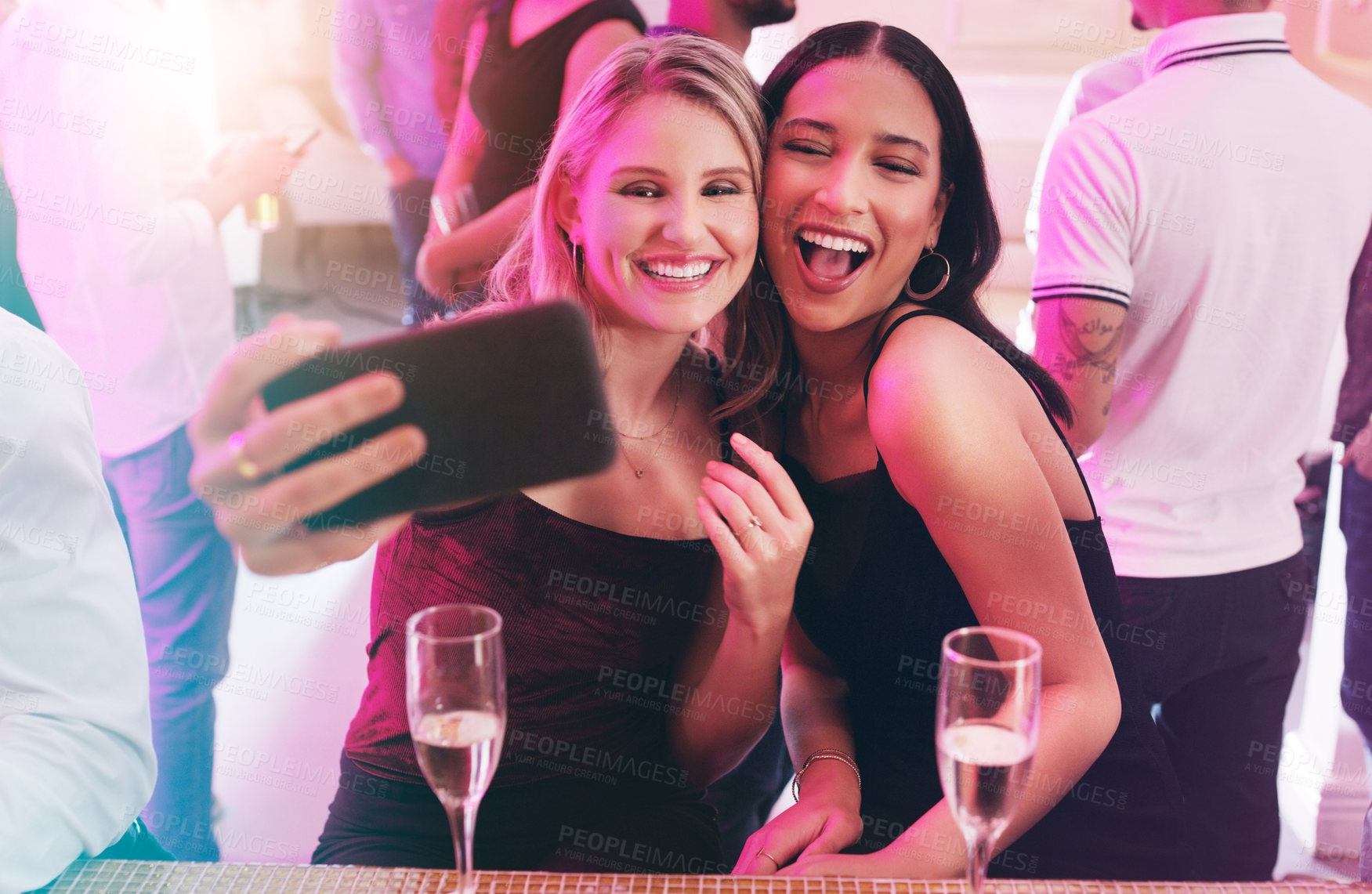 Buy stock photo Shot of two young women taking a selfie together in a nightclub
