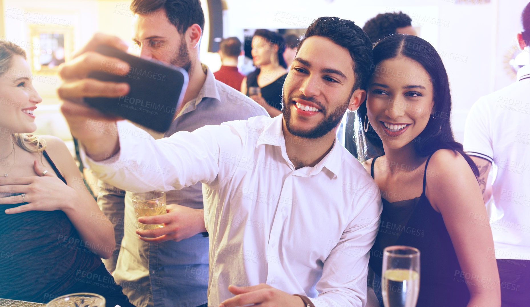 Buy stock photo Shot of a young man and woman taking a selfie together in a nightclub