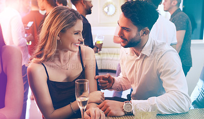 Buy stock photo Shot of a young man and woman chatting in a nightclub