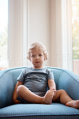 Buy stock photo Portrait of an adorable little boy playing sitting on a sofa at home