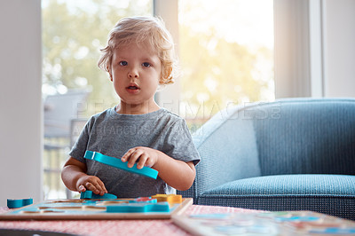 Buy stock photo Portrait of an adorable little boy playing with toys at home