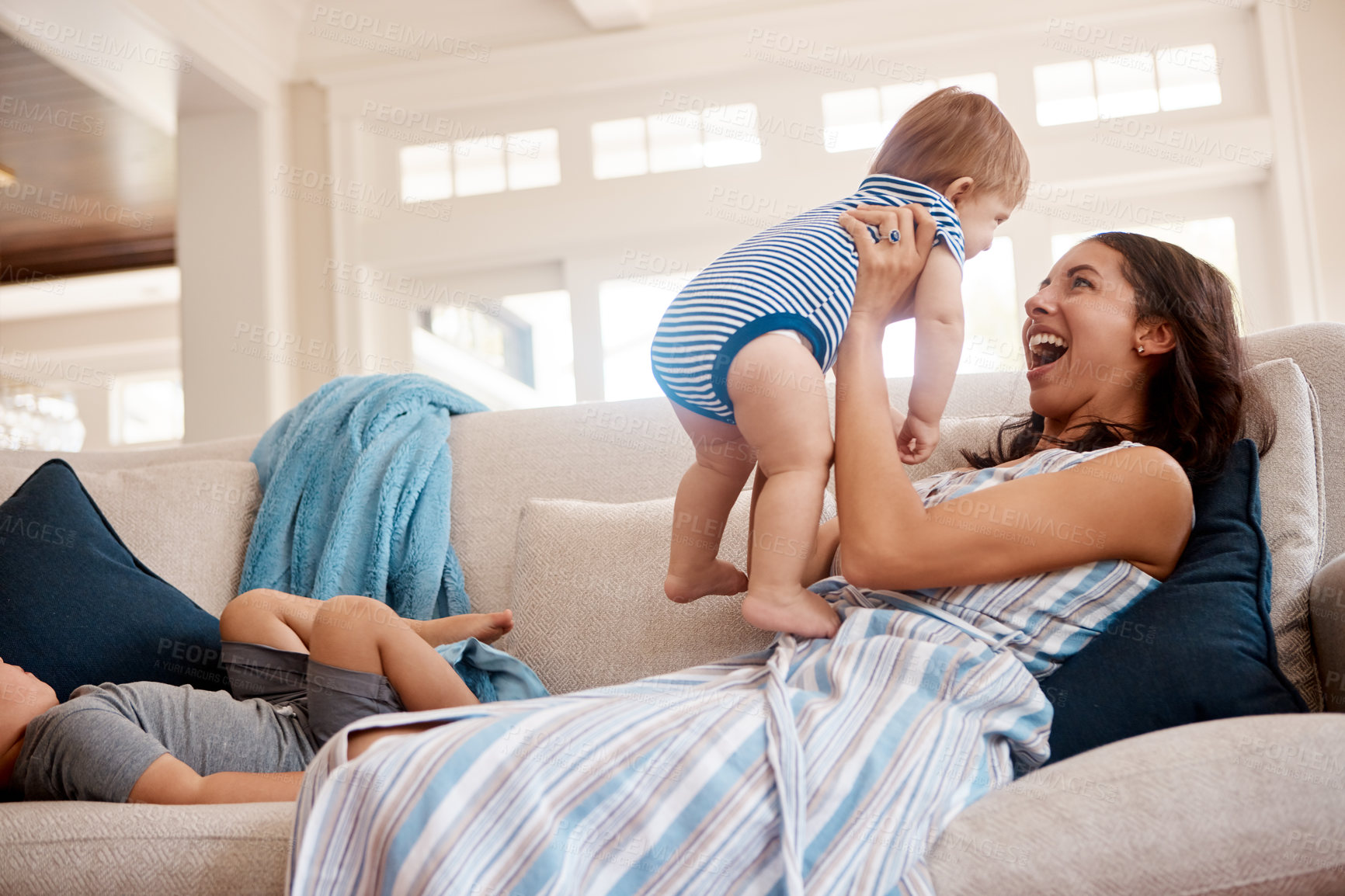 Buy stock photo Smile, play and mom with baby on sofa for bonding, family relationship and child development. Motherhood, living room and happy children with mother for support, lazy weekend and relax together