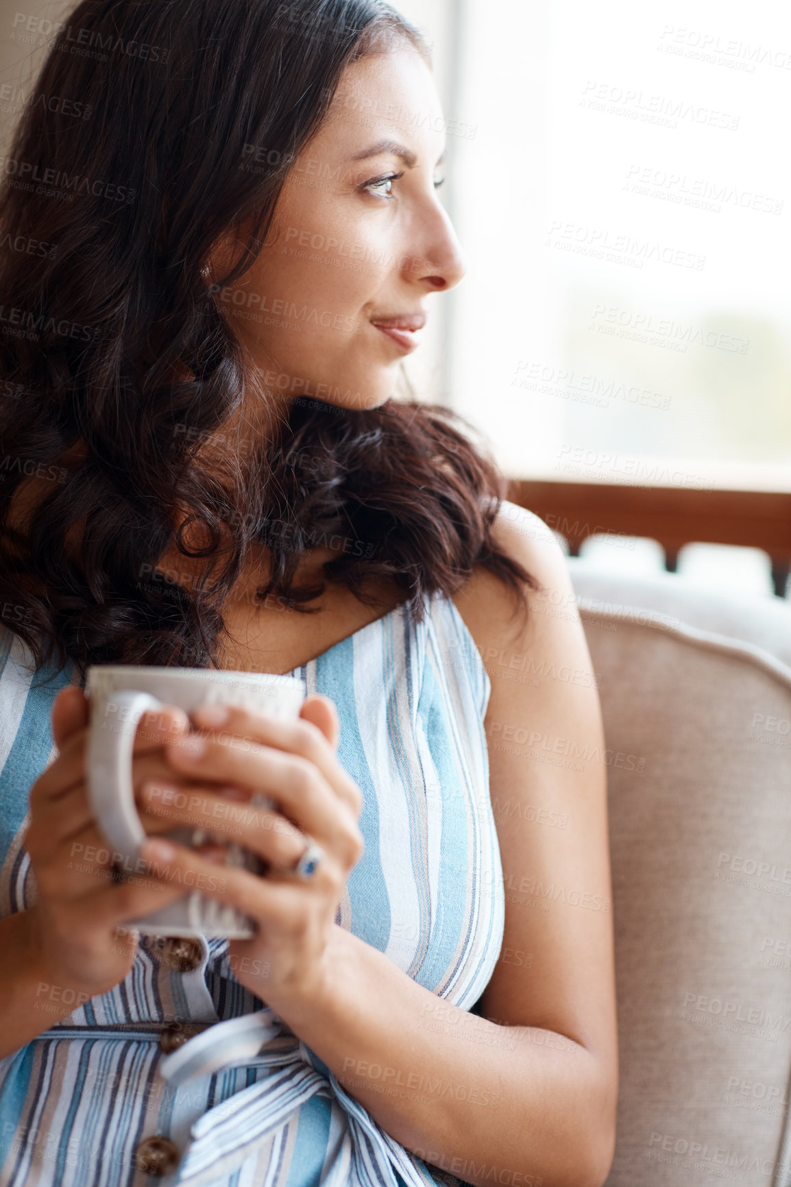 Buy stock photo Shot of a young woman drinking coffee while relaxing on the porch at home