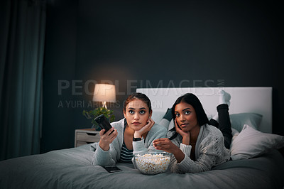 Buy stock photo Girls night, young women and popcorn while watching television on a bed in bedroom. Relaxing or entertainment, fun and female friends with snack with streaming movie or series together at home