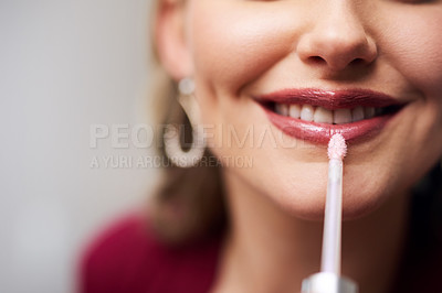 Buy stock photo Closeup shot of a beautiful young bride applying lipstick while preparing for her wedding in her dressing room