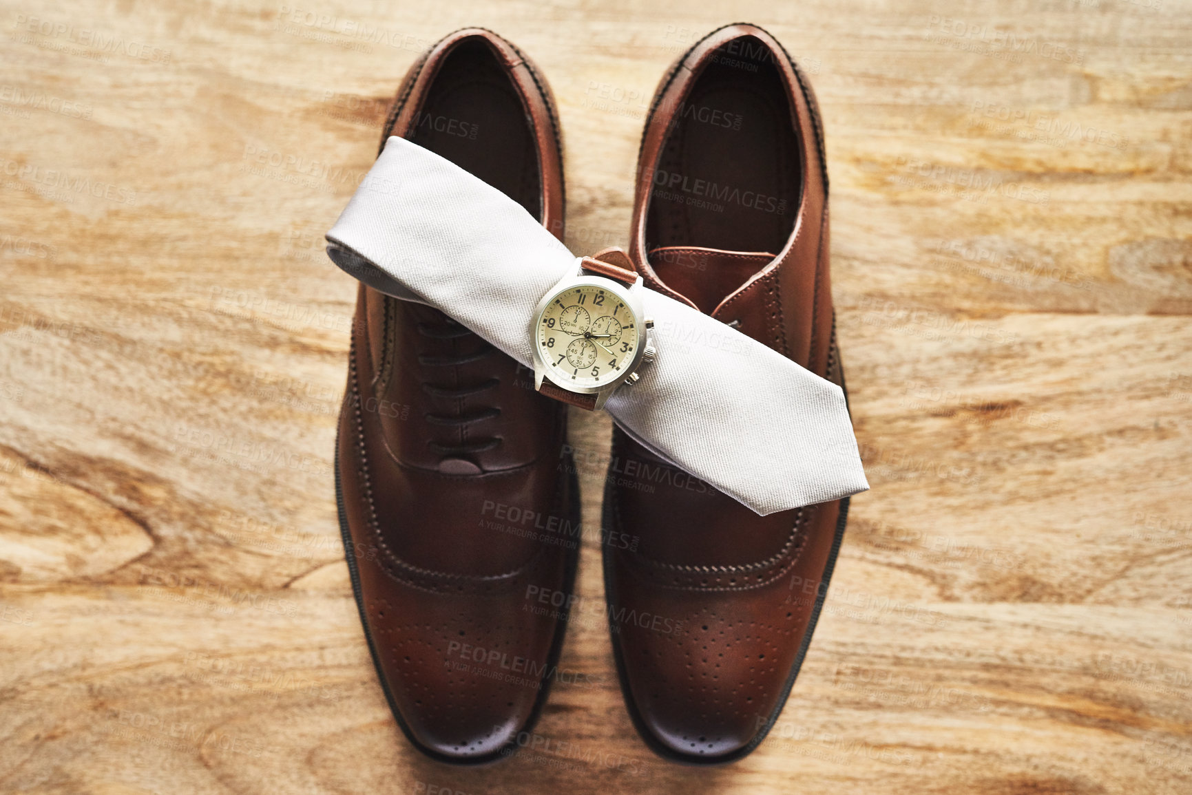 Buy stock photo Still life shot of a wristwatch and tie on top of formal shoes on a wooden surface