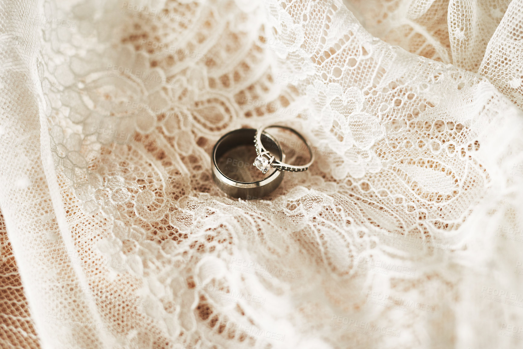 Buy stock photo Still life shot of two beautiful wedding rings on top of a wedding dress