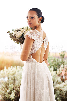 Buy stock photo Portrait of a beautiful young bride holding a bouquet of flowers outdoors on her wedding day