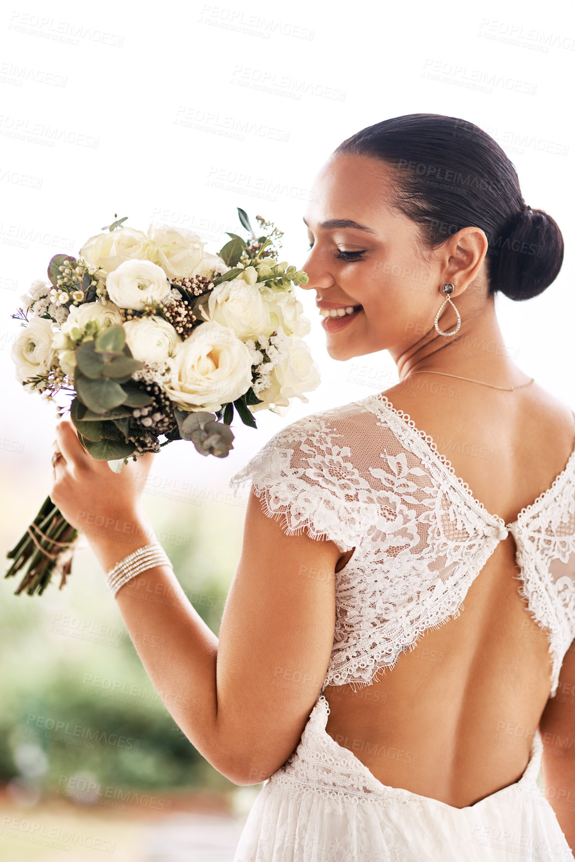 Buy stock photo Shot of a beautiful young bride holding a bouquet of flowers outdoors on her wedding day