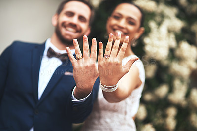 Buy stock photo Shot of a happy newlywed young couple showing their rings on their wedding day