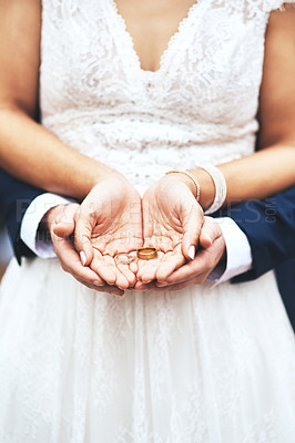 Buy stock photo Cropped shot of an unrecognizable newlywed couple holding and showing their rings on their wedding day