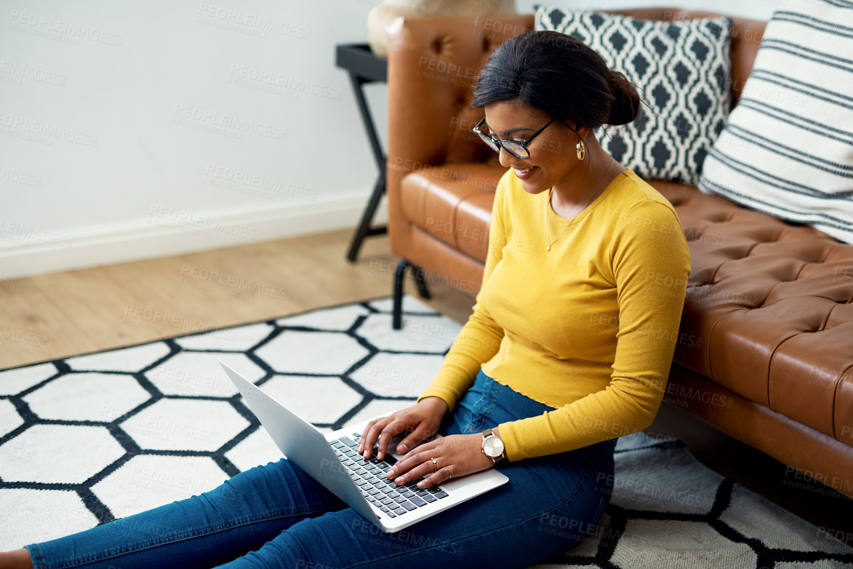Buy stock photo Cropped shot of an attractive young woman sitting on the floor and using her laptop at home