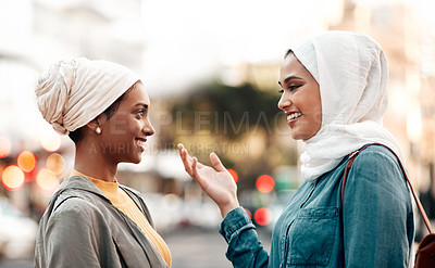 Buy stock photo Cropped shot of an attractive young woman wearing a hijab and talking with her female friend while touring the city