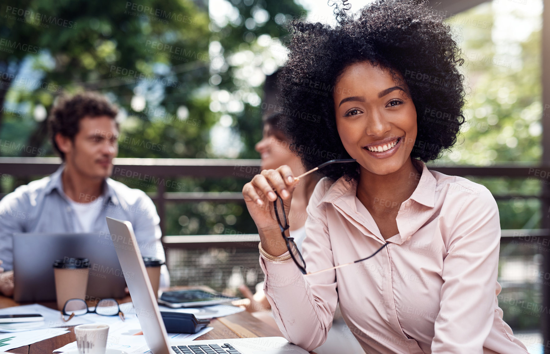 Buy stock photo Cropped portrait of an attractive young businesswoman sitting with her colleagues during a meeting outside the office