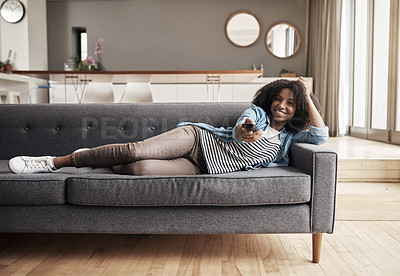 Buy stock photo Sofa, African woman watching tv and with remote on the couch in living room of her home. Entertainment or relax, happiness and comfortable black female person streaming series or a movie in free time