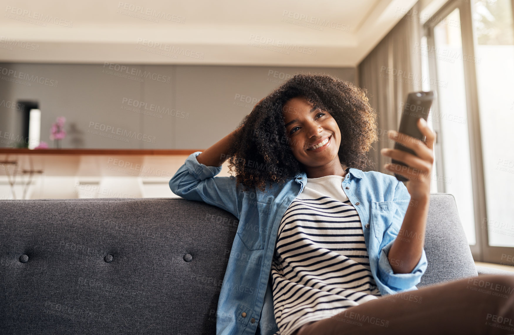 Buy stock photo Relax, black woman with remote and watching tv on sofa in living room of her home. Entertainment or comfort, streaming movie or a series and happy African female person watch television on a couch 