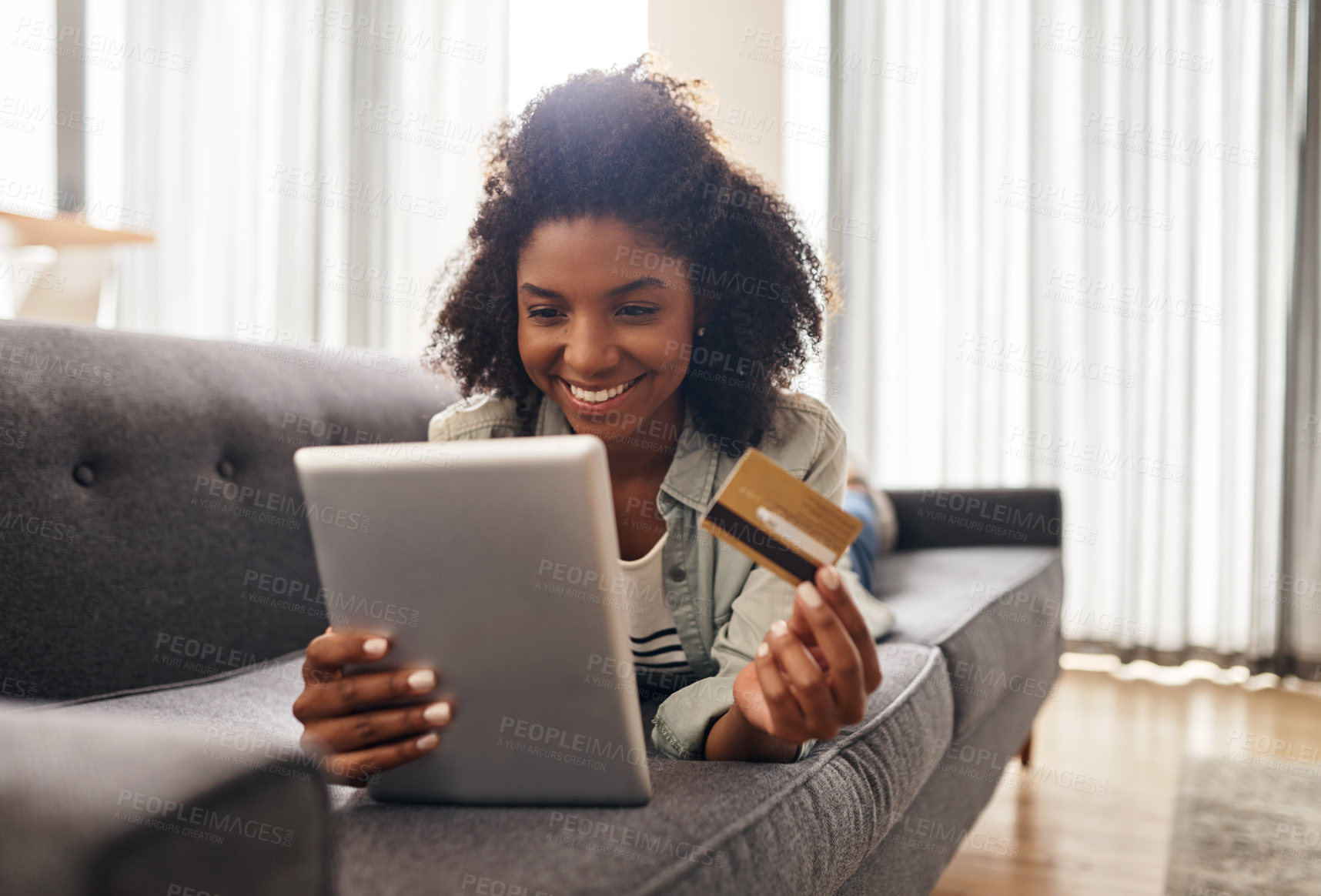 Buy stock photo Shot of a woman holding a credit card while using a digital tablet