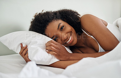 Buy stock photo Cropped shot of a young woman lying in bed