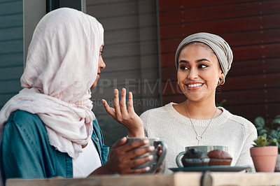 Buy stock photo Cropped shot of two affectionate young girlfriends having a chat at a coffee shop while dressed in hijab