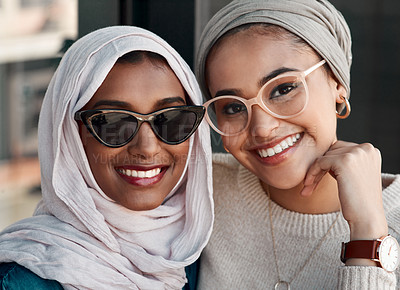 Buy stock photo Cropped portrait of two affectionate young girlfriends hanging out together in a cafe while dressed in hijab