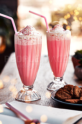 Buy stock photo Still life shot of two milkshakes and some cookies placed on a table at a cafe during the day