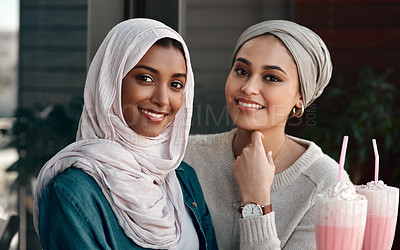 Buy stock photo Cropped portrait of two affectionate young girlfriends hanging out together at a milkshake cafe while dressed in hijab