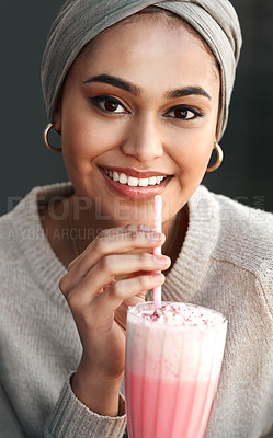 Buy stock photo Cropped portrait of an attractive young woman enjoying a milkshake at a cafe while wearing a headscarf