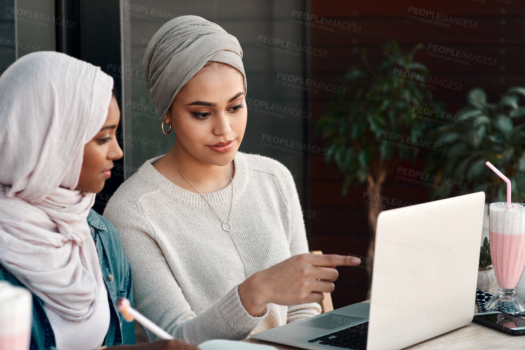 Buy stock photo Laptop, restaurant and muslim women talking, planning and online education for remote e learning, studying and teamwork. Islamic people, friends or students in Saudi Arabia check computer at a cafe