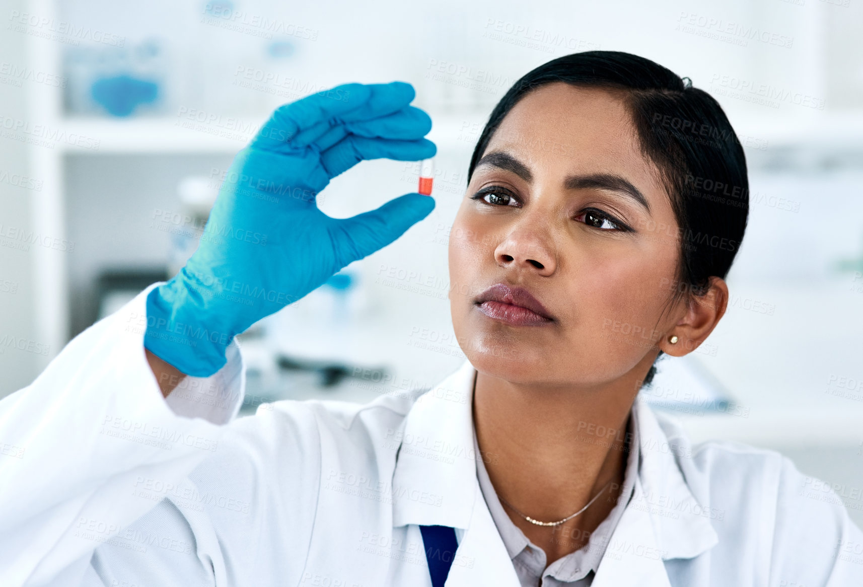 Buy stock photo Cropped shot of an attractive young female scientist inspecting a tablet while working in a laboratory