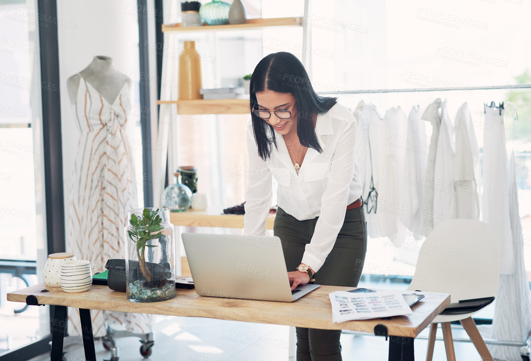Buy stock photo Shot of a young business owner using a laptop in her store