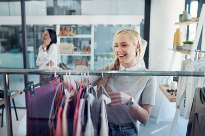 Buy stock photo Shot of a young woman shopping for clothes in a store