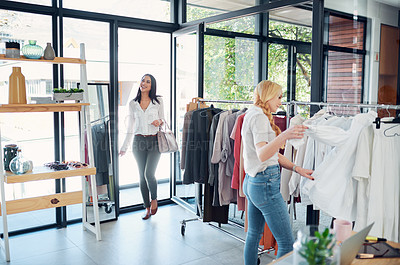 Buy stock photo Shot of two young women shopping in a clothing store