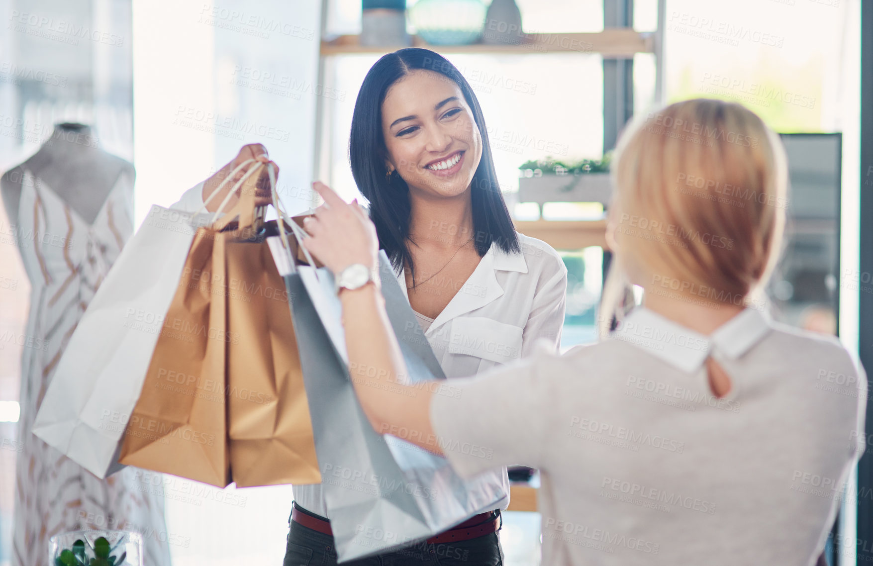 Buy stock photo Happy staff helping a woman doing fashion shopping and spending on her favorite designer store. A stylish, excited and wealthy female buying clothes and enjoying good customer service