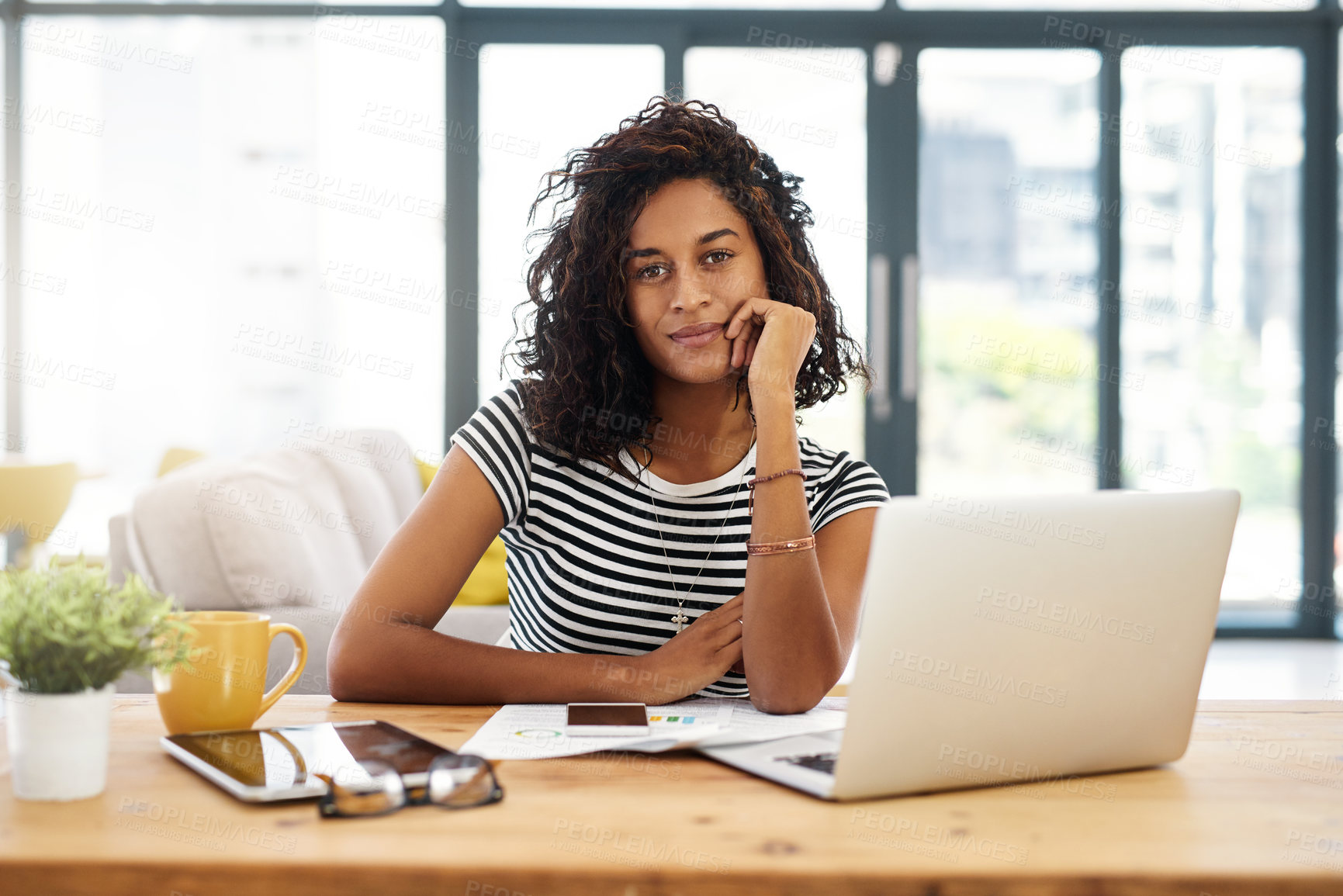 Buy stock photo Cropped portrait of an attractive young businesswoman sitting alone and working from home during the day