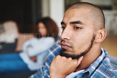 Buy stock photo Cropped shot of a handsome young man looking upset after an argument with his wife in their home