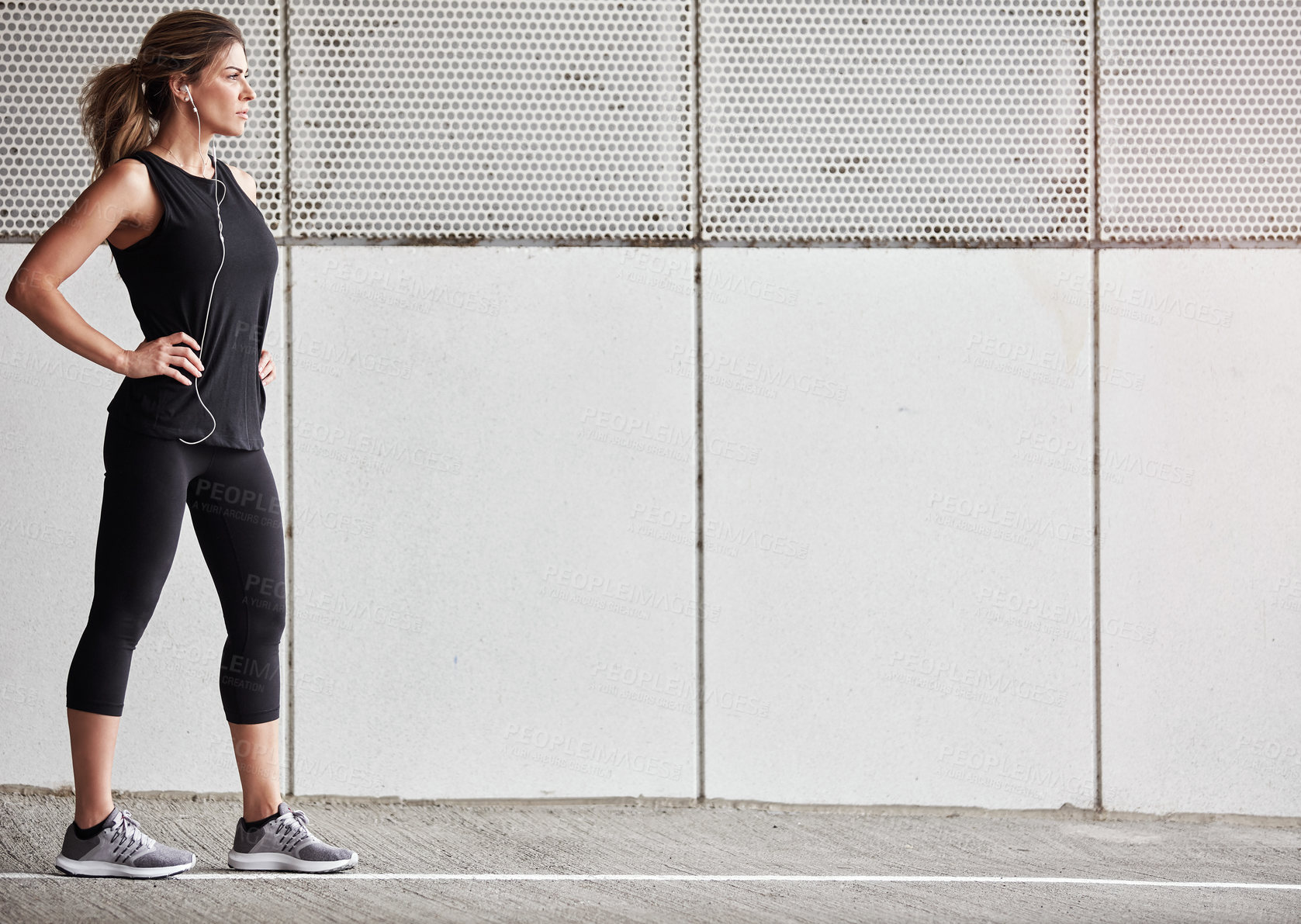 Buy stock photo Shot of a sporty young woman taking a break while exercising outdoors