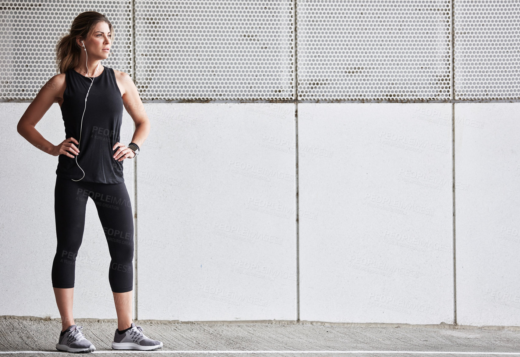 Buy stock photo Shot of a sporty young woman taking a break while exercising outdoors