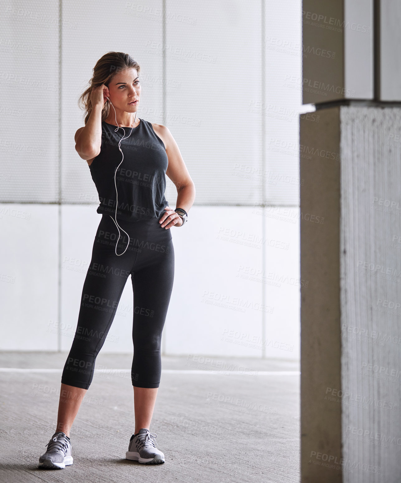 Buy stock photo Shot of a sporty young woman taking a break while exercising outdoors